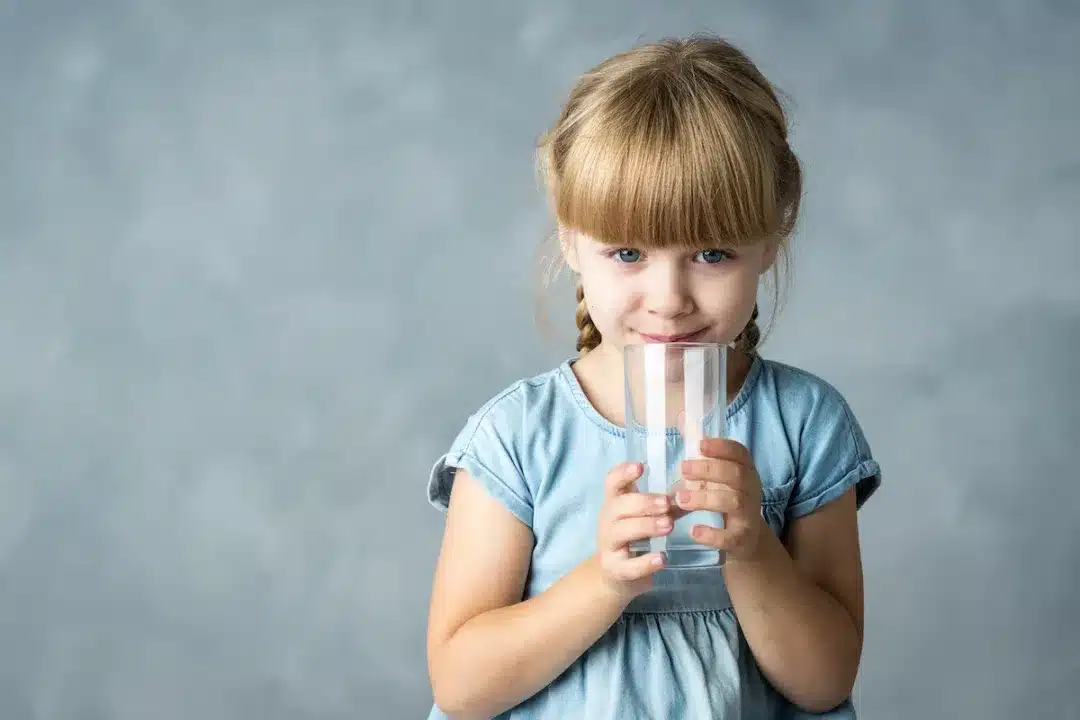 Little,Girl,In,A,Blue,Dress,On,A,Gray,Background