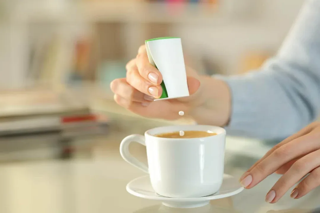 Close,Up,Of,Woman,Hand,Throwing,Saccharin,Pills,On,Coffee