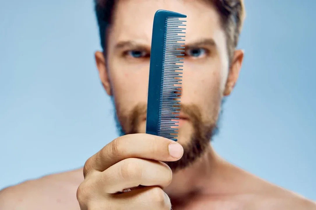 Young,Guy,With,A,Beard,On,A,Blue,Background,Holds